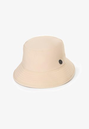 Beige bucket hat made of soft fabric with a round, structured crown and a wide, sloping brim. Features a decorative black logo on the side.