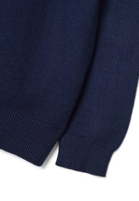 Suéter de punto azul marino con puños acanalados. La textura de la tela es suave y uniforme. Las mangas muestran detalles de costura y material suave y elástico.