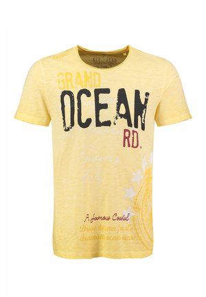 Geel T-shirt met korte mouwen met grote zwarte en rode tekst, een gestructureerd ontwerp en subtiele vervaagde accenten. Bevat gestileerde grafische elementen en patronen.