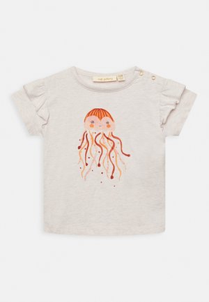 Chemise pour tout-petit beige clair avec des manches courtes à volants, ornée d'une illustration souriante d'une méduse orange aux longs tentacules sur le devant.