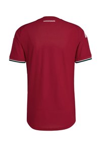 Maillot de sport rouge à manches courtes avec le texte « Magyarország » sur le haut du dos et un bord à rayures verte, blanche et rouge aux poignets.