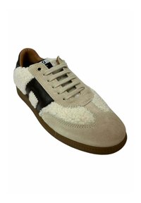Zapatillas de ante beige y piel de cordero crema, con acentos de cuero marrón oscuro, cordones redondos y una suela de goma texturizada.