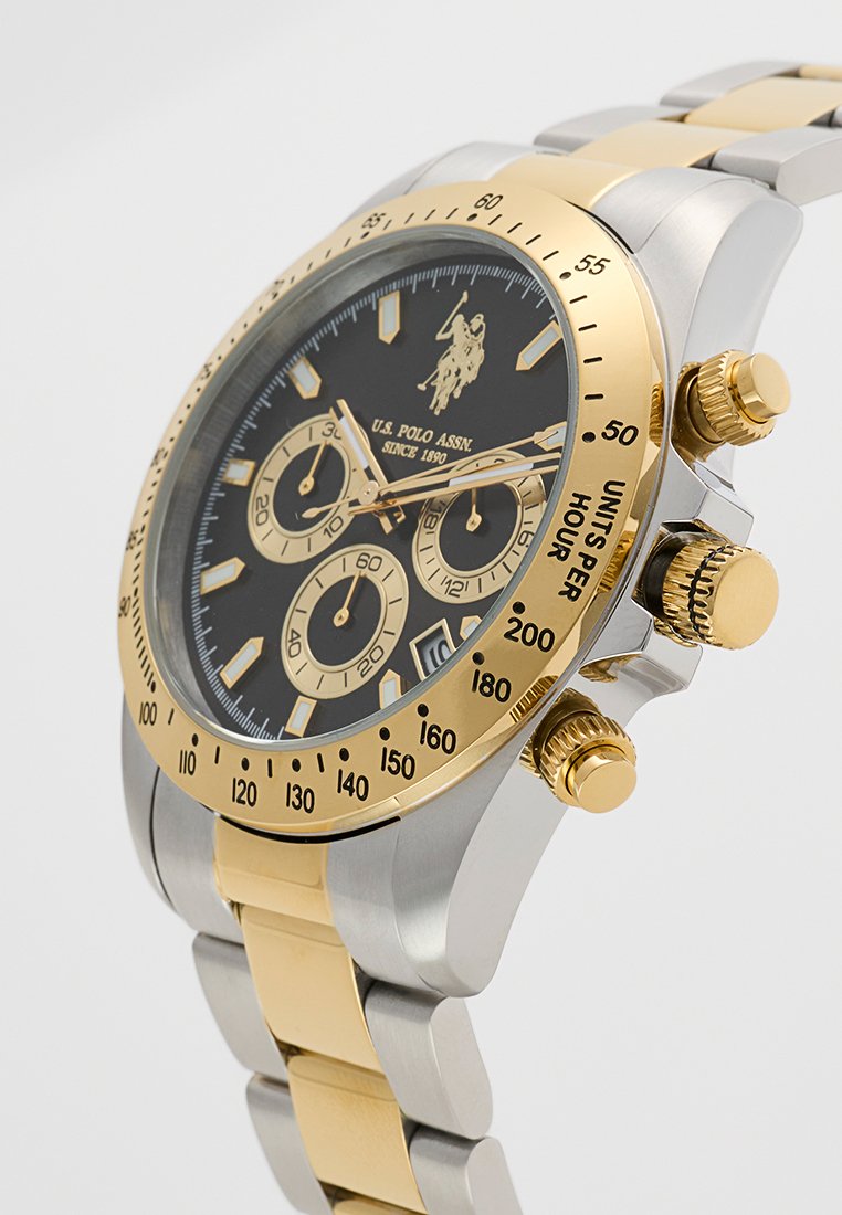 Orologio cronografo con quadrante nero, dettagli dorati, bracciale in acciaio inossidabile e tono oro, dotato di tre sottodial e corona testurizzata.