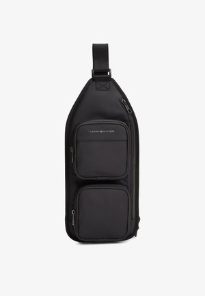 Borsa a tracolla nera in tessuto resistente con due tasche con cerniera, tracolla regolabile e logo Tommy Hilfiger impresso sul davanti.