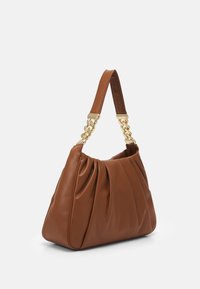 Borsa a spalla in pelle marrone con morbide pieghe e dettagli in catena dorata sulla tracolla, su sfondo bianco semplice.