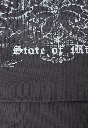 Tumma harmaa ribbackangas, jossa on teksturoitu pinta ja valkoisia painettuja kuvioita sekä lause "Mielen tila" koristeellisella fontilla.