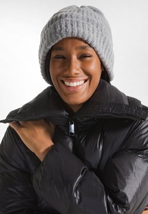 Gray knitted beanie and black puffer jacket with a shiny zipper. The jacket has a high collar and a smooth, padded texture.