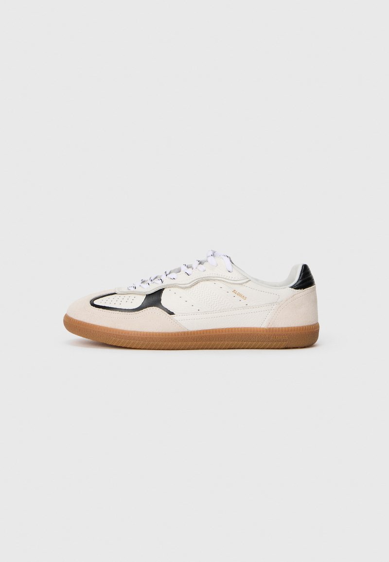 White and black sneaker with suede and leather materials, perforated details, flat white laces, and a gum rubber sole.