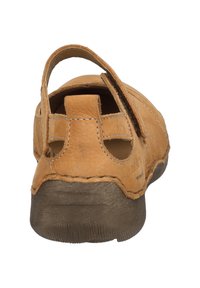 Zapato de cuero color cuero con un tacón curvado, correa en la parte posterior y detalles laterales cortados. Suela texturada con un tono marrón contrastante. Acentos cosidos visibles.