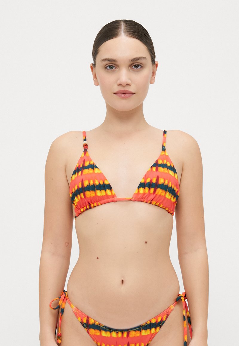 Driehoek bikini top in levendig oranje met zwarte en gele strepen, gemaakt van gladde stof. Verstelbare bandjes en een zij-tie onderkant ontwerp.