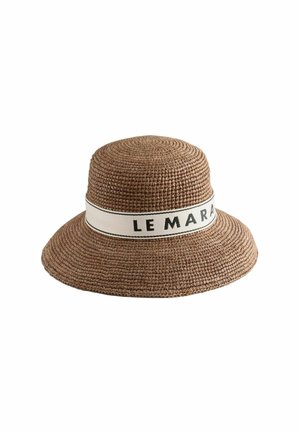 Bruine gevlochten zonneklep hoed met brede rand en witte band met gedeeltelijke zwarte tekst "LE MARA" rond de kroon.