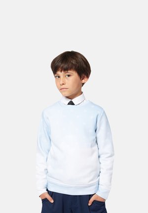 Sweatshirt bleu clair avec un design dégradé, présentant de subtils motifs blancs. Manches longues et encolure côtelée, associé à un pantalon sombre.