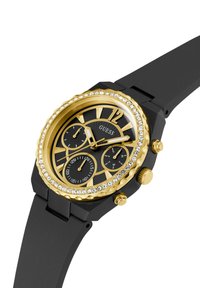 Orologio con cinturino in silicone nero, lunetta dorata, dettagli in cristallo, quadrante nero, indici delle ore dorati e tre sottodial per la misurazione del tempo.