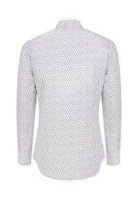 Biała koszula z długim rękawem, ozdobiona rozproszonym wzorem z czerwonych i niebieskich kropek, z klasycznym kołnierzykiem i zaokrąglonym dołem. Miękka tekstura materiału.