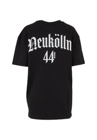 Čierne tričko s krátkym rukávom z bavlny s nápisom "Neukölln" a "44" potlačeným tučným bielym gotickým písmom na chrbte. Jednoduchý dizajn, uvoľnený strih.