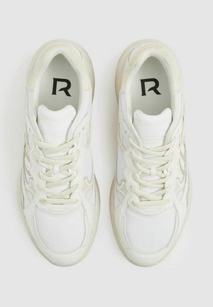 Le sneaker atletiche bianche presentano una tomaia in mesh e pelle, dettagli testurizzati, logo sulla soletta e chiusura con lacci.