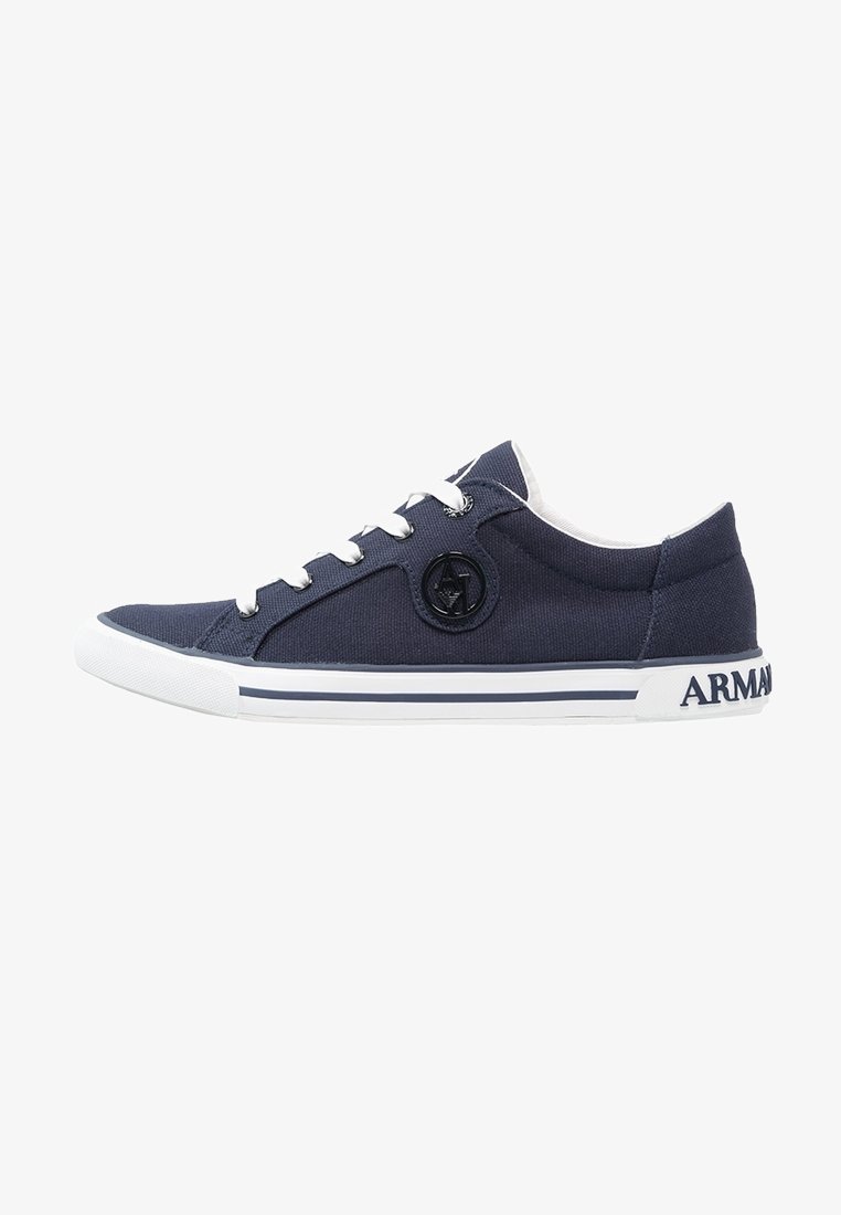 Marineblaue Segeltuch-Sneaker mit weißer Gummisohle, abgerundetem Zehenbereich, Schnürdesign, kreisförmigem Emblem an der Seite und "ARMANI"-Logo an der Ferse.