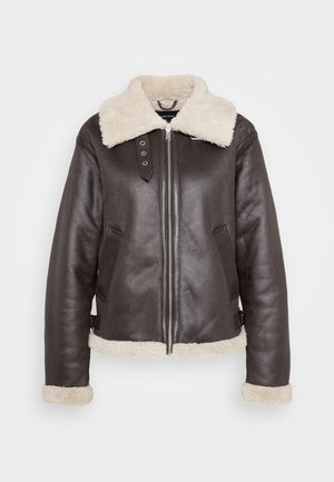 Jachetă din piele maro cu guler, mansete și margine din blană crem, fermoar frontal, buzunare laterale și curele cu catarame la talie.