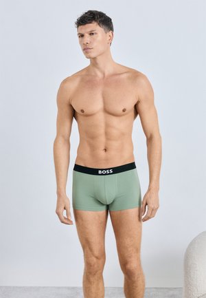 Grüne Boxer-Slips aus weichem Stoff mit einem schwarzen Bund, der das "BOSS"-Logo trägt. Sie sitzen eng anliegend und haben einen modernen Schnitt.