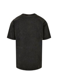 Tricou din bumbac negru, cu mâneci scurte, croială relaxată, decolteu rotund, textură ușor decolorată, cu detalii de cusătură pe margini, vedere din spate.