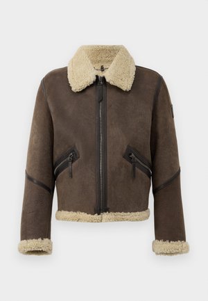 Bruine schapenleren jas met een nep-shearling kraag, voorritssluiting en twee schuin geplaatste ritssluitingen. Geaccentueerd met zwarte leren afwerkingen.