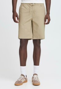Beige shorts lavet af en bomuldsblanding, med elastisk talje og snøre, sidelommer og lige bendesign.