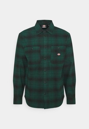 Groen-zwart geruit overhemd met lange mouwen en knopen, met twee borstzakken aan de voorkant, waarvan één met een kleine ronde logopatch.