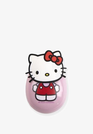 Accessoire in de vorm van Hello Kitty met een witte kop met zwarte omranding, een rode strik en een roze lichaam met een rode jurk. Glad oppervlak.
