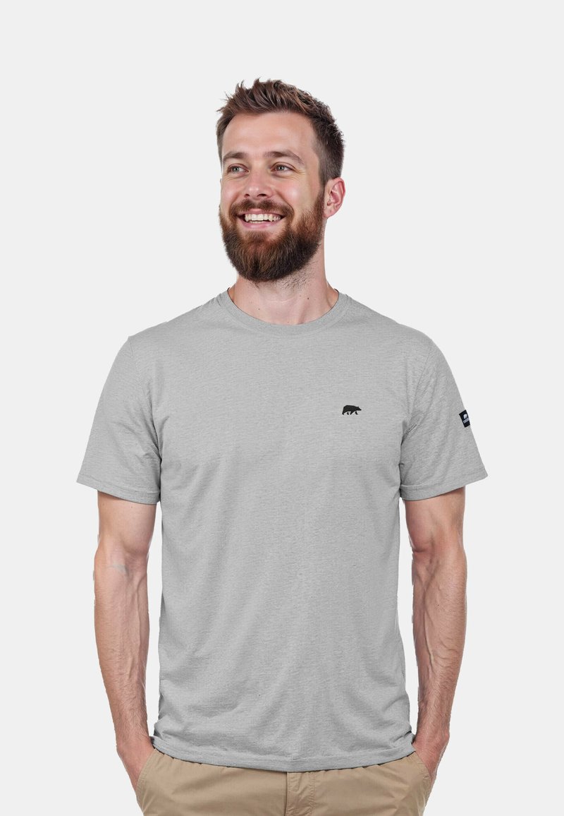 Hellgraues T-Shirt aus einem weichen Stoff, mit einem kleinen schwarzen Bärenlogo auf der Brust und einem Etikett am Ärmel. Kurze Ärmel und Rundhalsausschnitt.