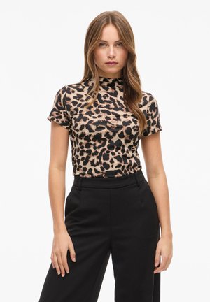 Short-sleeve leopard print top in beige and black, with a high neckline and form-fitting design, paired with tailored black trousers.
