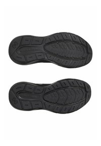 Black athletic shoe soles with textured rubber surface, grooves for traction, and "Under Armour" logo embossed on one sole.