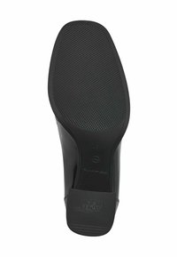 Semelle de chaussure en caoutchouc noir avec un motif de grip texturé, bout arrondi et petit talon. Les marquages incluent "Antidérapant" et les détails de taille.