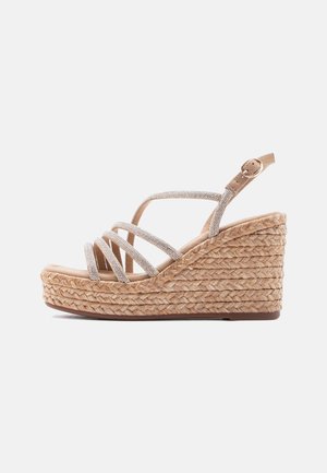 Sandale compensée espadrille avec plateforme en corde tressée et fines lanières scintillantes, dotée d'une fermeture à boucle cheville dans des tons beige.