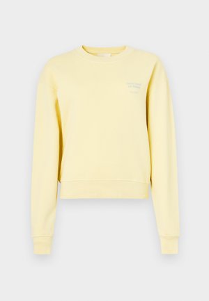 Yellow cropped sweatshirt made of soft fabric, featuring long sleeves and a round neckline. Text printed in light blue on the front.