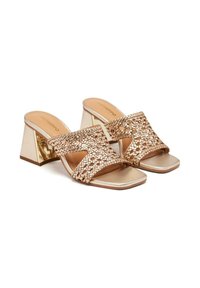 Mules à talons dorés avec un design supérieur tissé, bout ouvert et talon bloc. Fini lisse avec un accent réfléchissant sur les talons.