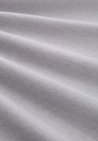 Lichtgrijze stof met een zachte textuur, met zachte plooien, een uniforme oppervlakte en een gelijkmatige kleurdistrubutie, die een gladde uitstraling vertoont.