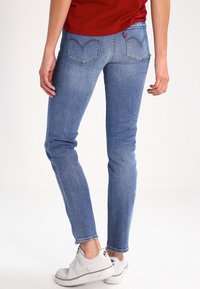 Tunna blå jeans i denim, med en klassisk femficksdesign, dekorerande sömmar och en liten märkesetikett på bakfickan.