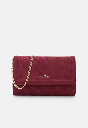 Lille rektangulær bordeaux clutch taske med guld kæderem og Anna Field logo på frontklappen mod hvid baggrund.