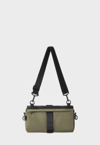 Borsa a tracolla verde oliva con tracolla nera regolabile, chiusura con zip e tasca frontale piatta. Presenta un tessuto resistente e accenti in metallo.