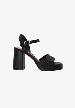 Zwarte leren hoge hak sandalen met een brede voorkantstrap, verstelbare enkelstrap en een chunky vierkante hak. Glad oppervlak en minimalistisch ontwerp.