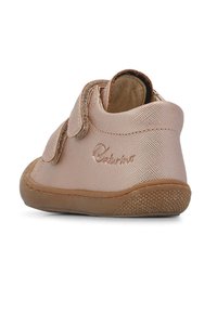 Růžová textilní obuv pro batolata s pevnou páskou na suchý zip, texturovaným povrchem a flexibilní gumovou podrážkou. Obsahuje logo vylisované na boku.