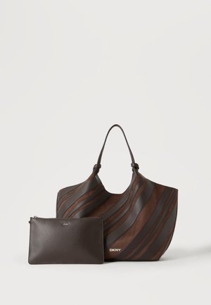Brun og mørkebrun stribet tote taske med en matchende ensfarvet lynlåspung, begge mærket DKNY, på en ensfarvet lys baggrund.