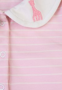 Tutina a righe rosa con colletto bianco e design di un giraffe ricamato. Il tessuto è morbido e presenta chiusure a bottoni a pressione.