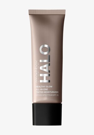 Beige klemflaske med sort hætte, mærket "smashbox HALO HEALTHY GLOW ALL-IN-ONE TINTED MOISTURIZER" og "BROAD SPECTRUM SPF 25."