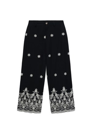Pantalon noir à jambes larges avec broderie florale blanche dispersée et densément répartie le long de l'ourlet, avec un bouton et des passants à la taille.