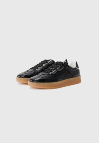 Sorte sneakers med krokodillepræg i gummi, udstyret med en gummisål, sorte snørebånd og en hvid polstret krave, som fremviser et slankt og struktureret design.