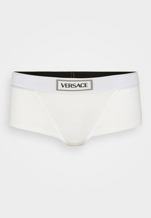 Witte katoenen boxershorts met een zwarte tailleband met een centraal Versace-logo, gladde textuur en elastisch materiaal voor comfort.