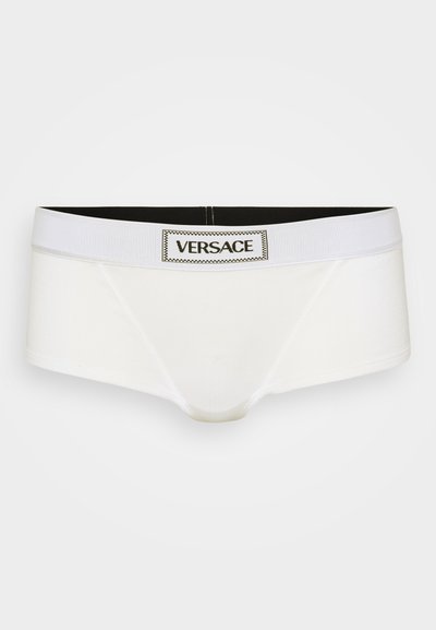 Boxer briefs brancos de algodão com uma cintura preta apresentando um logotipo central da Versace, textura suave e material elástico para conforto.