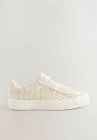 Baskets beiges à enfiler avec une tige en tissu tissé texturé, semelle en caoutchouc blanche et design minimaliste. Sans lacets, avec une doublure lisse.