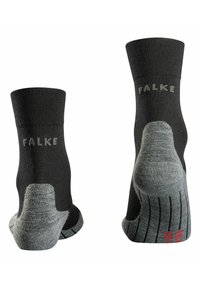 Chaussettes de cheville noires et grises avec un talon texturé, logo "FALKE" en gris, orteil renforcé et motif antidérapant sur la semelle pour une meilleure traction.